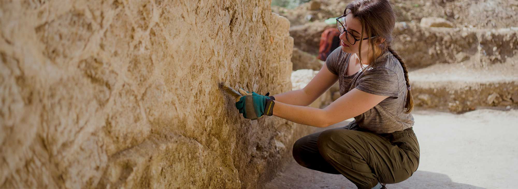 A person is excavating an ancient wall.